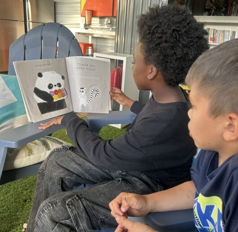 Child reading to younger child
